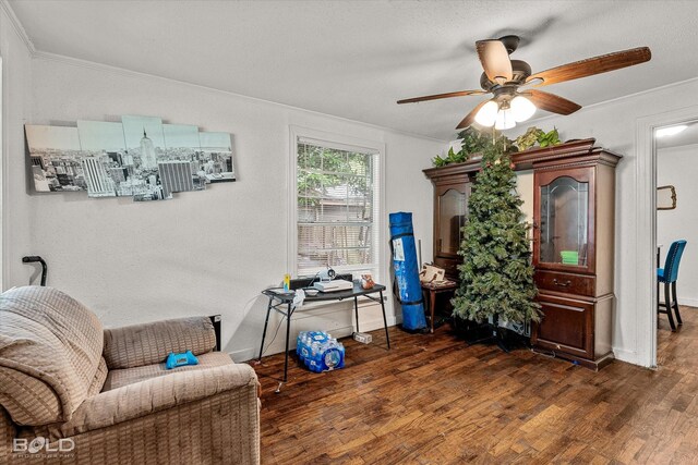living area with baseboards, ornamental molding, a ceiling fan, and dark wood-style floors