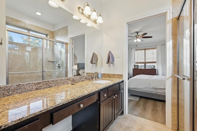 ensuite bathroom with ensuite bathroom, ceiling fan, tile patterned flooring, vanity, and a shower stall