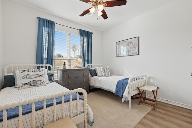 bedroom featuring ceiling fan, baseboards, and wood finished floors