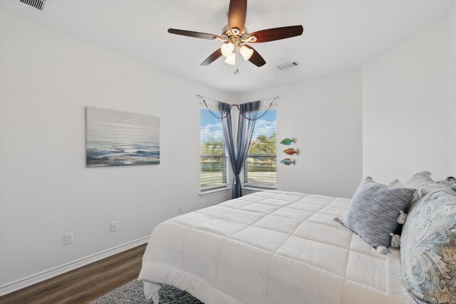 bedroom with visible vents, ceiling fan, baseboards, and wood finished floors