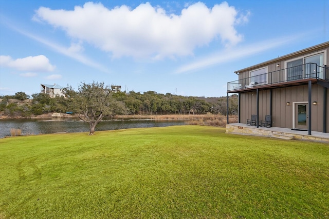 view of yard with a water view, a patio, and a balcony