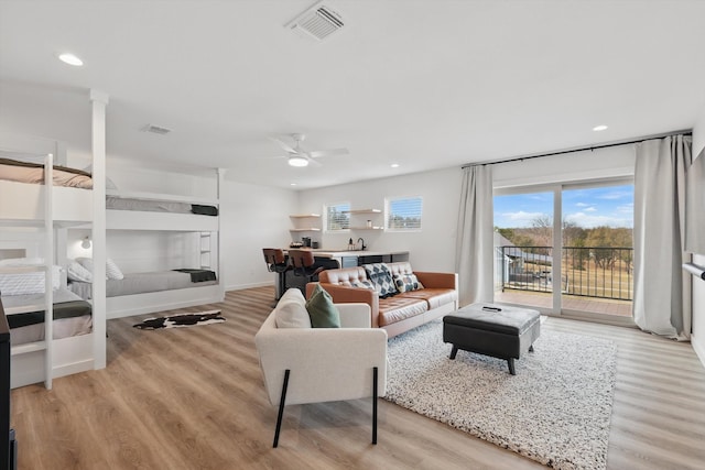 living area with light wood finished floors, ceiling fan, and visible vents