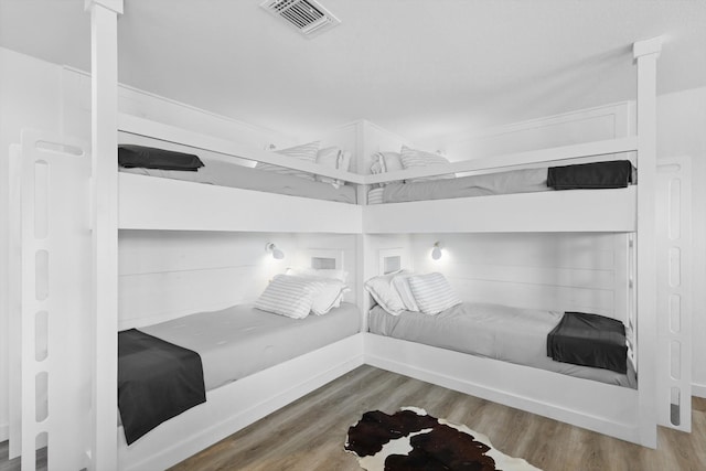 bedroom featuring visible vents and wood finished floors