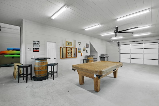 game room with a garage, concrete floors, billiards, and a ceiling fan