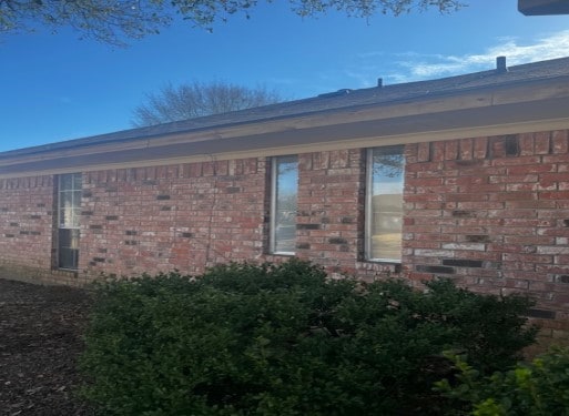 view of side of home featuring brick siding