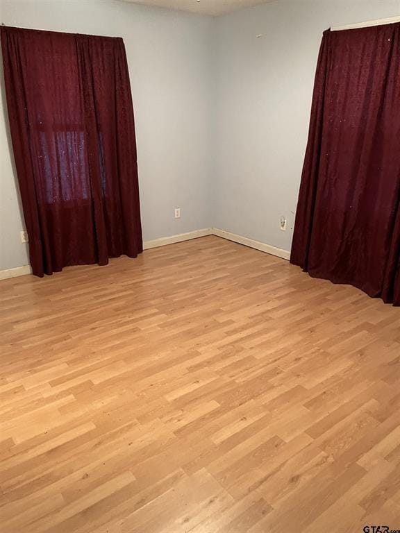 empty room featuring light wood-style flooring and baseboards