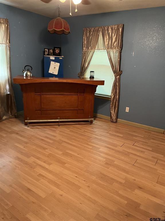 bedroom with wood finished floors, a ceiling fan, and baseboards