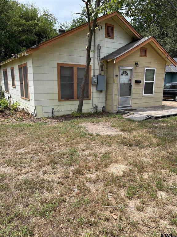 rear view of house featuring a patio area and a lawn