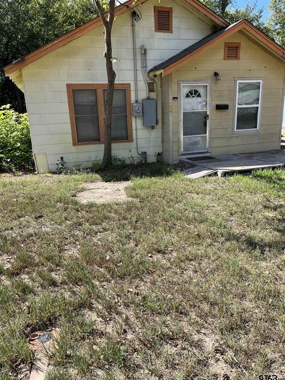 rear view of property featuring a yard