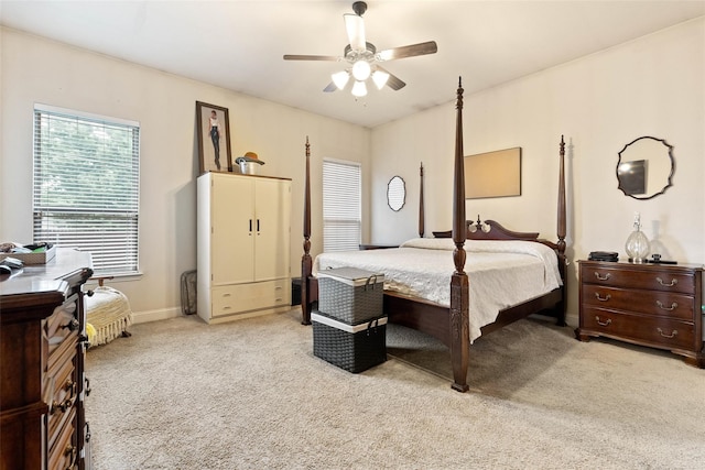 bedroom featuring ceiling fan, baseboards, and light colored carpet