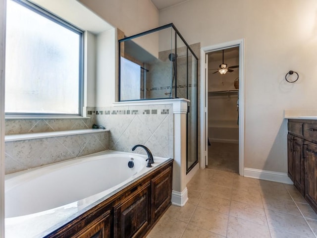 full bathroom with vanity, a spacious closet, a bath, tile patterned floors, and a stall shower