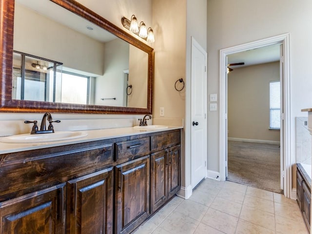 full bathroom with a sink, baseboards, and double vanity