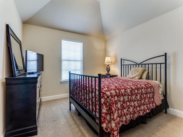 bedroom with carpet, baseboards, and vaulted ceiling