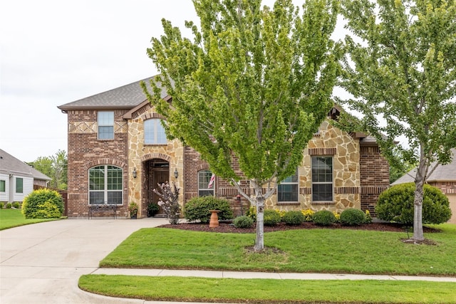 view of front of home with stone siding, brick siding, and a front lawn