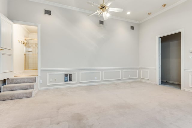 unfurnished room featuring light carpet, ornamental molding, visible vents, and a decorative wall