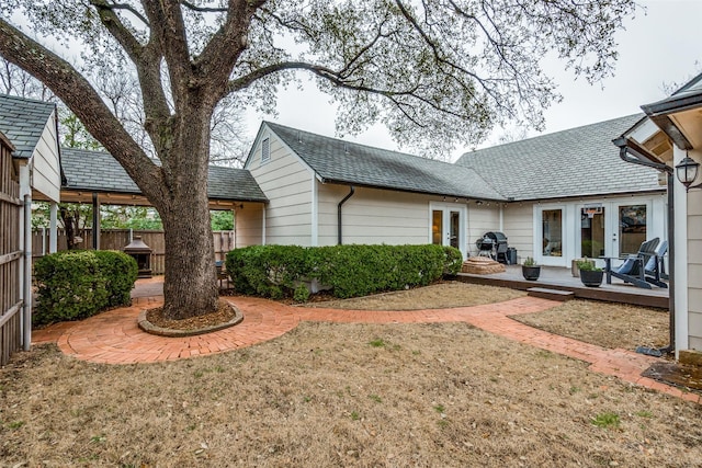 back of property featuring a yard, french doors, fence, and a patio