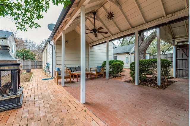 view of patio featuring a ceiling fan, fence, and an outdoor living space