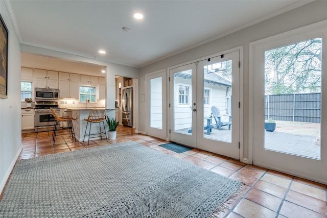 doorway with baseboards, ornamental molding, french doors, and recessed lighting