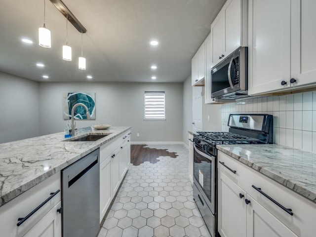 kitchen with appliances with stainless steel finishes, white cabinets, and a sink