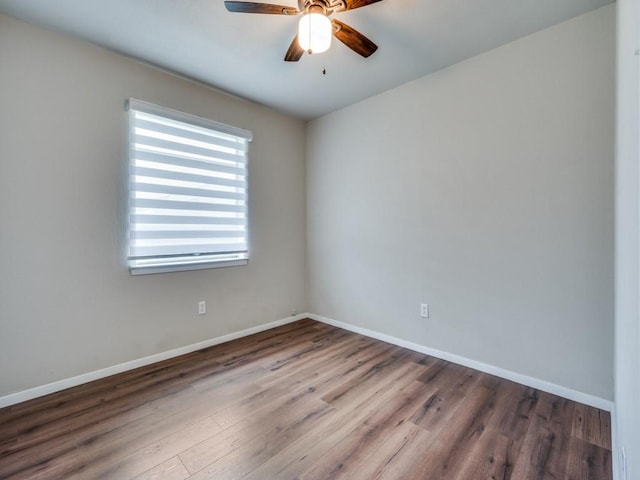 empty room featuring ceiling fan, wood finished floors, and baseboards