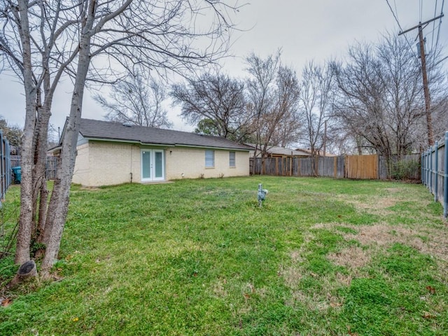 view of yard featuring french doors and a fenced backyard