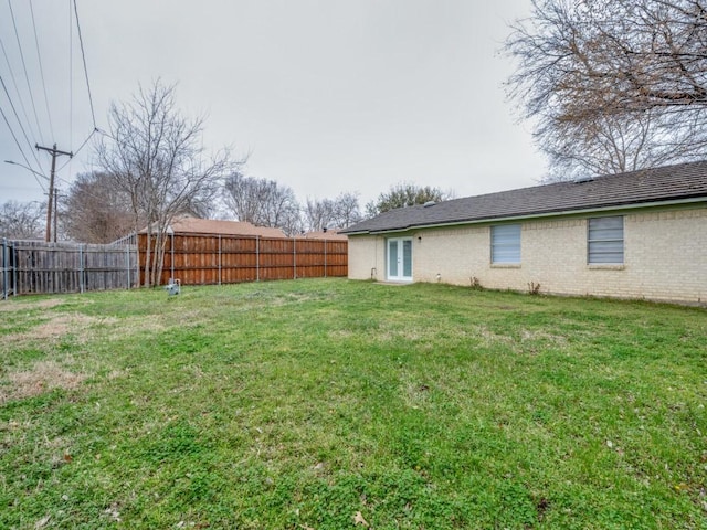 view of yard with a fenced backyard and french doors