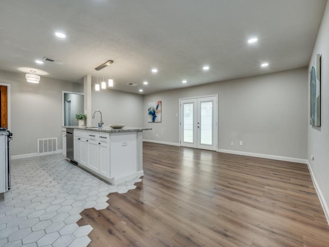 kitchen featuring french doors, visible vents, open floor plan, and white cabinetry