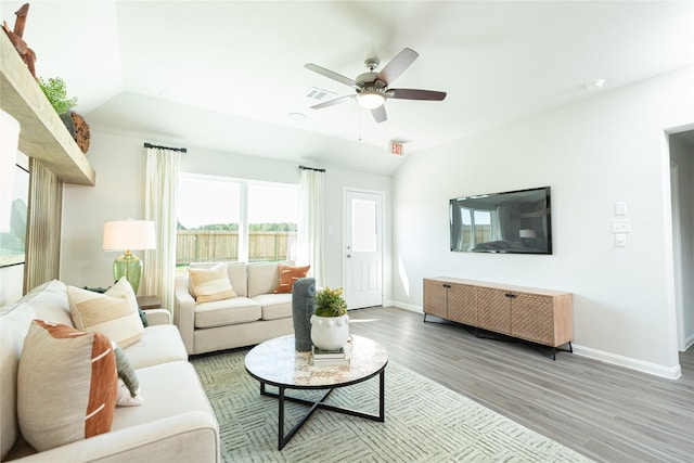 living area with wood finished floors, a ceiling fan, visible vents, vaulted ceiling, and baseboards