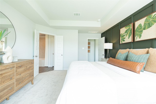 bedroom featuring baseboards, visible vents, a tray ceiling, and carpet flooring