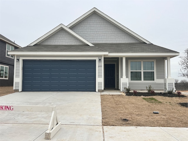 view of front of property featuring an attached garage, concrete driveway, and roof with shingles