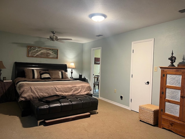 bedroom featuring carpet floors, visible vents, a textured ceiling, and baseboards