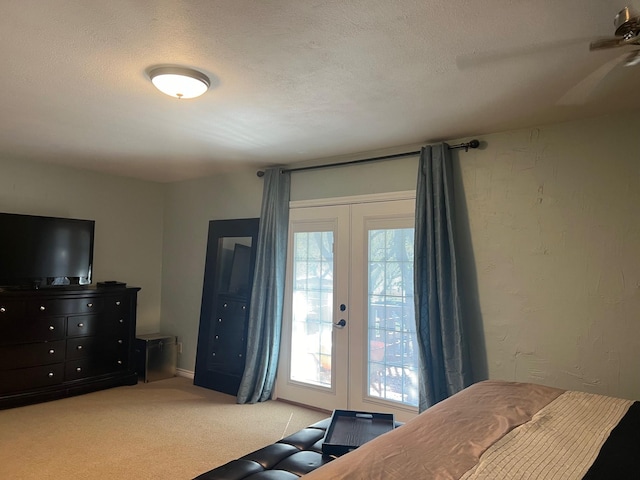 bedroom with french doors, a textured wall, light carpet, a textured ceiling, and access to outside