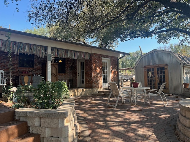 view of patio / terrace with outdoor dining area, french doors, and an outdoor structure