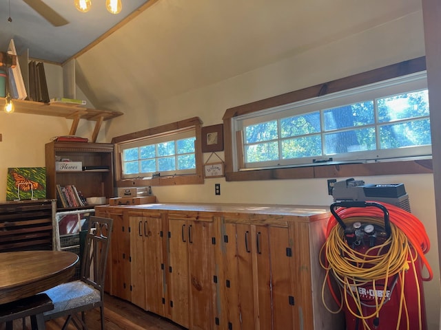 kitchen featuring lofted ceiling, brown cabinets, wood finished floors, light countertops, and open shelves