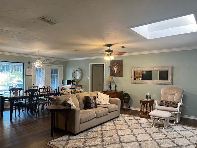 living room with crown molding, dark wood finished floors, visible vents, ceiling fan, and baseboards