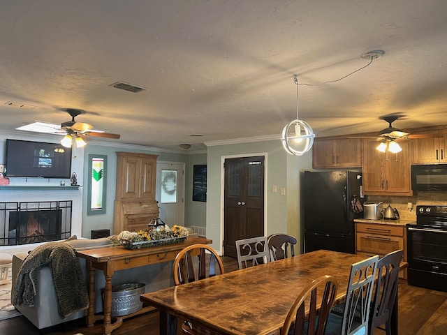 dining space with dark wood-style flooring, crown molding, a fireplace, visible vents, and a ceiling fan