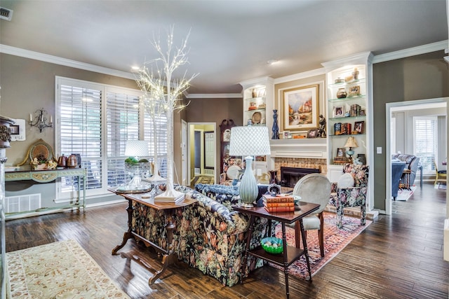 living area featuring visible vents, wood finished floors, an inviting chandelier, crown molding, and a fireplace