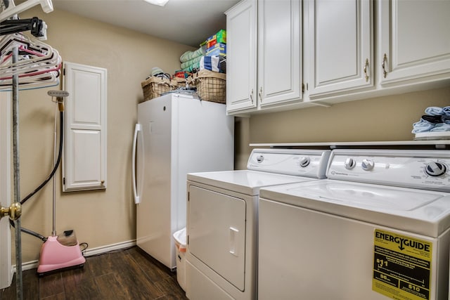 clothes washing area featuring washer and dryer, dark wood-style flooring, and cabinet space