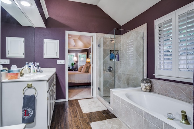 ensuite bathroom with ensuite bathroom, wood finished floors, vaulted ceiling, a shower stall, and a bath