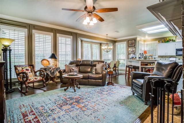 living area featuring dark wood-type flooring, visible vents, crown molding, and ceiling fan with notable chandelier