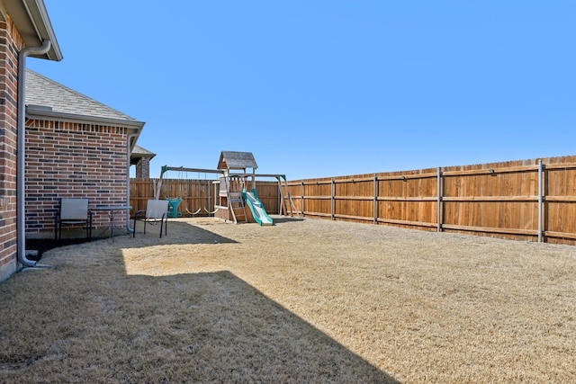 view of yard with a playground and a fenced backyard