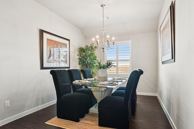 dining room featuring a notable chandelier, visible vents, vaulted ceiling, wood finished floors, and baseboards