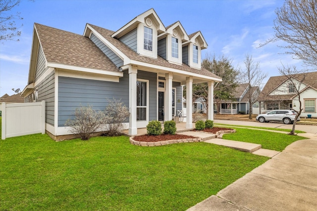 cape cod-style house with a shingled roof, fence, a porch, and a front yard