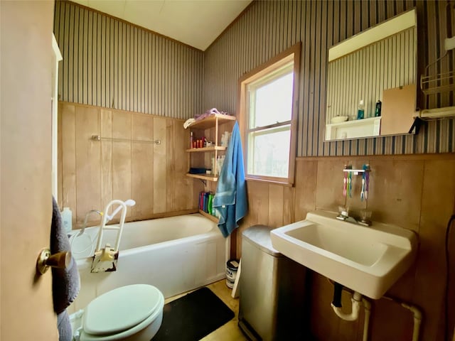 full bath featuring a sink, a bathtub, toilet, and wallpapered walls