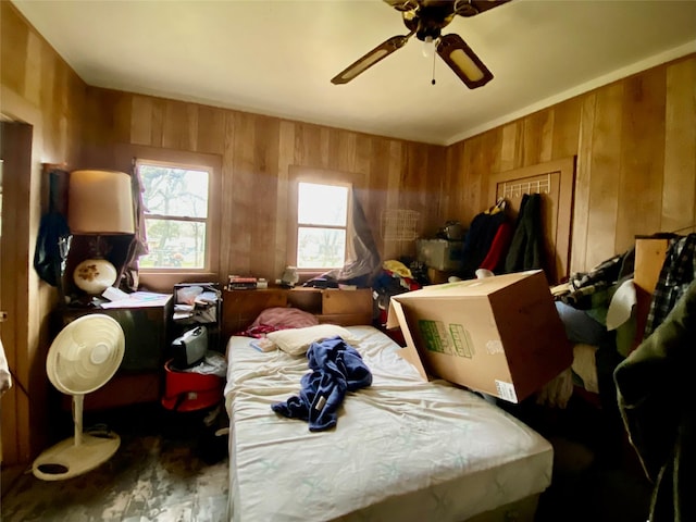 bedroom with ceiling fan and wooden walls