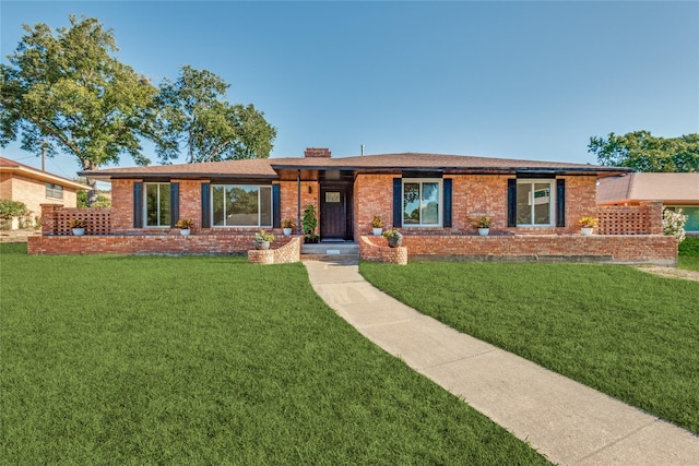 ranch-style home with a front yard, brick siding, and a chimney