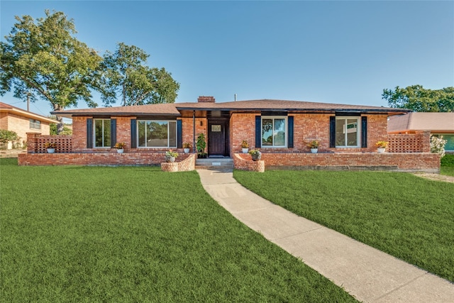 ranch-style house with brick siding, a chimney, and a front yard