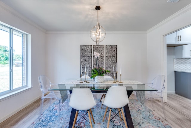 dining room featuring ornamental molding, a notable chandelier, light wood finished floors, and baseboards