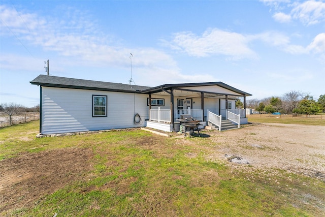 back of house featuring a porch and a yard