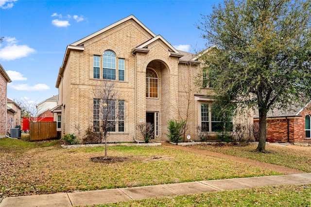 traditional-style house featuring cooling unit, brick siding, and a front lawn